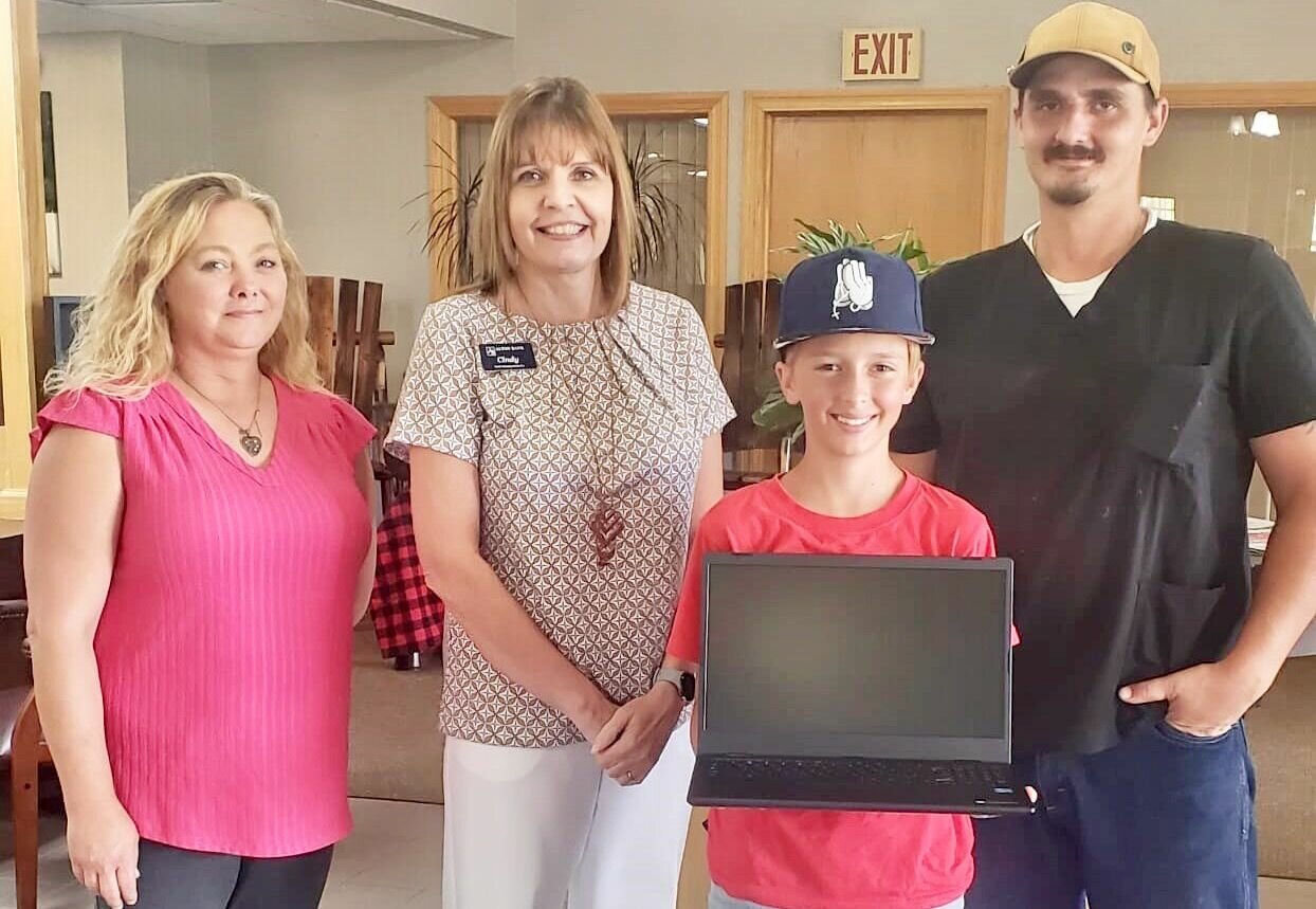 The Bank of Birch Tree branch of Alton Bank recently gave away four Chromebooks to students from each of the schools in Mtn. View-Birch Tree School District. Andrew Messex from Liberty Middle School holds his new Chromebook. With him, from left, are bank employees Linda Camden and Cindy Bradford, and Andrew’s father, name not given.