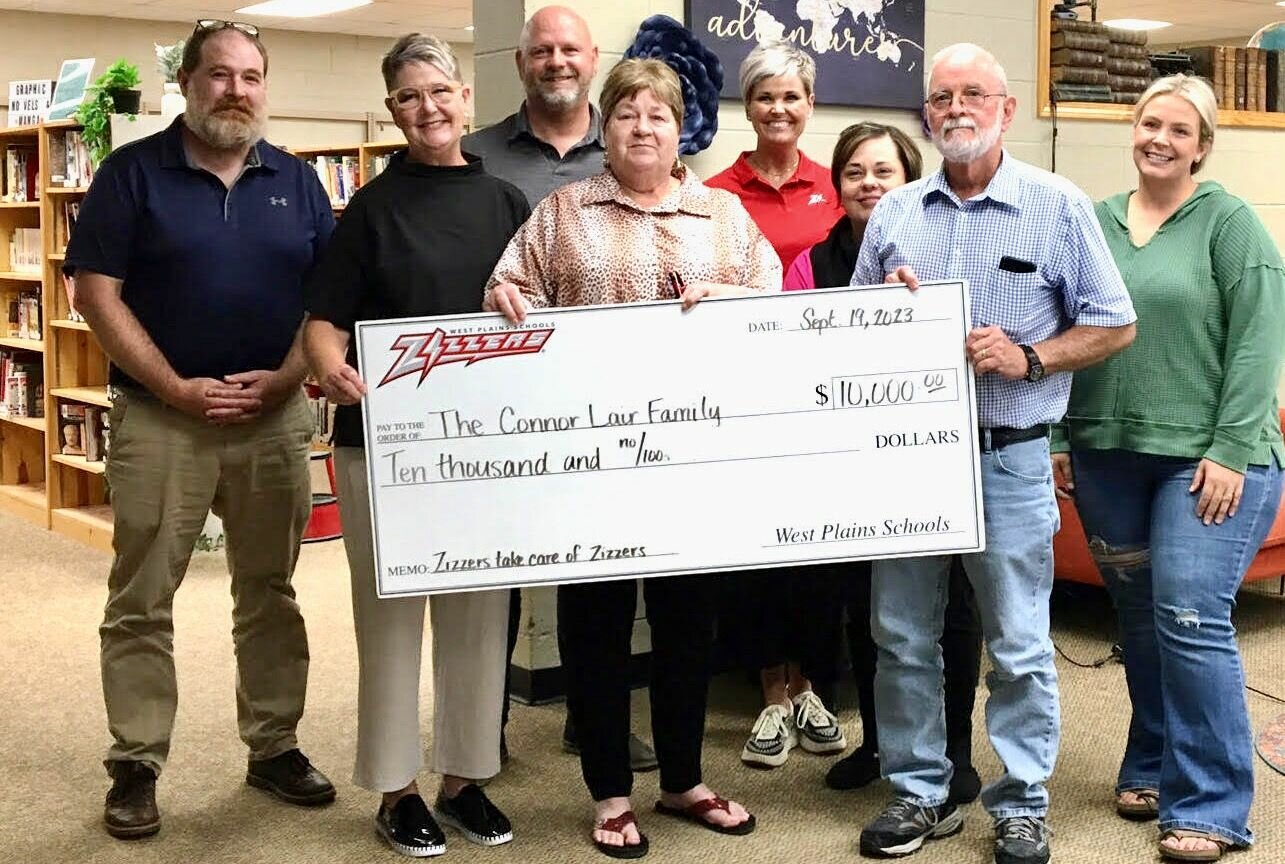 "We always say once a Zizzer, always a Zizzer. We talk about the Zizzer family, and in true Zizzer fashion the Zizzer family wants to help the family of Connor Lair," West Plains R-7 School Board President Jim Thompson said at the beginning of the board’s September meeting. A check for $10,000 was presented to the Lair family by the board, including gate proceeds from the Sept. 15 Homecoming game, donations from Rolla High School, passing a football helmet to collect cash donations and purple sticker sales. Lair is a 2022 West Plains High School graduate and Zizzer football standout who was recently diagnosed with Hodgkin's lymphoma. He is now attending Missouri State University in Springfield, playing football for the Bears, and has begun treatment at St Jude Children's Research Hospital in Memphis, Tenn. From left: board member Reid Grigsby, Vice President Cindy Tyree and member Brian Mitchell; Lair's grandmother Carolyn Honeycutt; Zizzer Athletics and Activities Director Ashley Cooley; and board member Christena Coleman, Thompson and member Jodi Purgason.