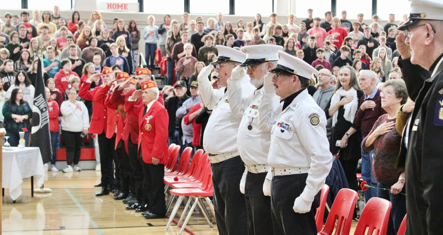 Local veterans, including a group of Marines at left, salute the American flag during the singing of the "Star Spangled Banner" by the West Plains High School Concert Choir. An assembly was held Friday morning at the high school to honor veterans following a breakfast sponsored by the school district and served by members of the high school Student Council.
